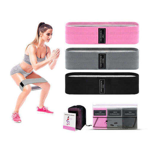 In this captivating image, a stylish woman effortlessly showcases the dynamic versatility of the 3-piece fabric resistance bands set. The set includes pink, dark grey, and black resistance bands.