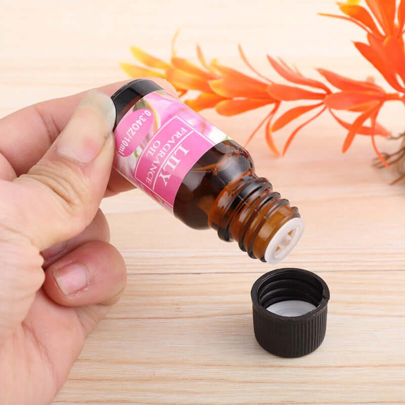 A hand dripping lily essential oil in a cap