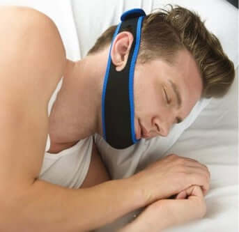 Man sleeping with an anti-snoring jaw strap