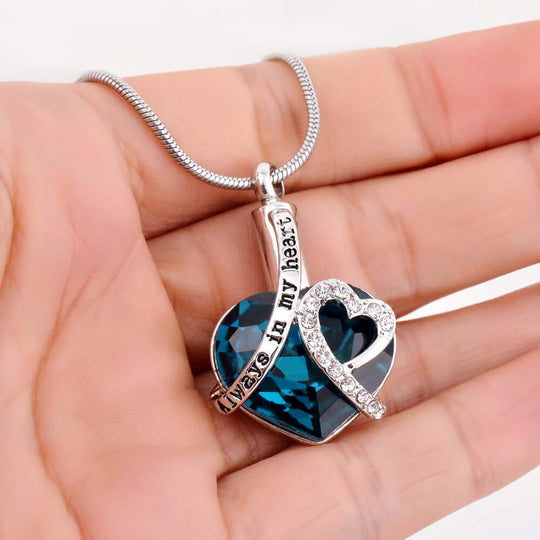 Blue always in my heart jewellery urn pendant and a chain on a human's hand